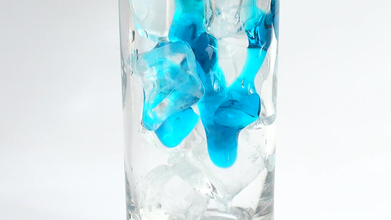 Preparazione di una bevanda con latte e ghiaccio e sciroppo blu.