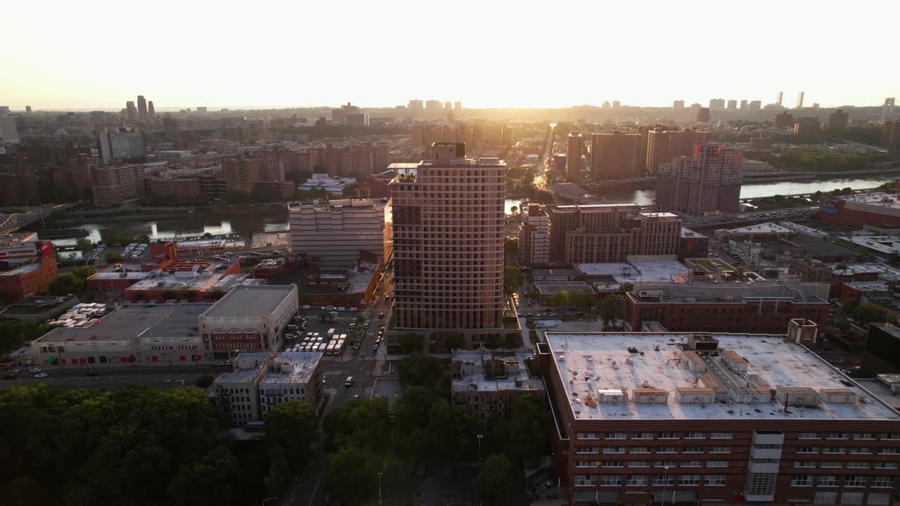 vista aérea descendiendo frente al edificio 425 grand concourse y el río harlem, en el soleado bronx, ny