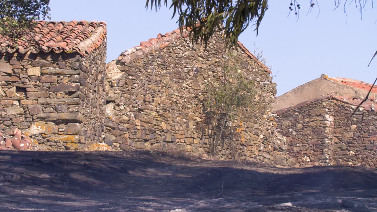 el terreno oscurecido y todavía humeante al lado de las casas de la montaña después de un incendio forestal