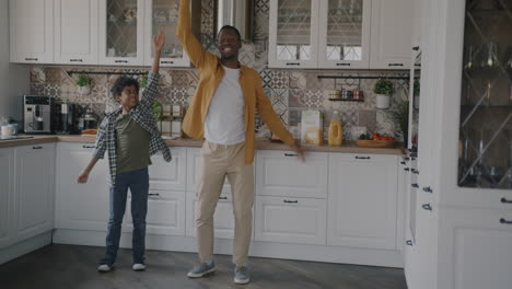 father and son dancing in the kitchen