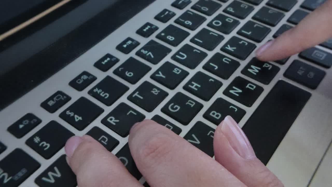 Front view of hands typing on a laptop, engaged in writing or creating digital content.