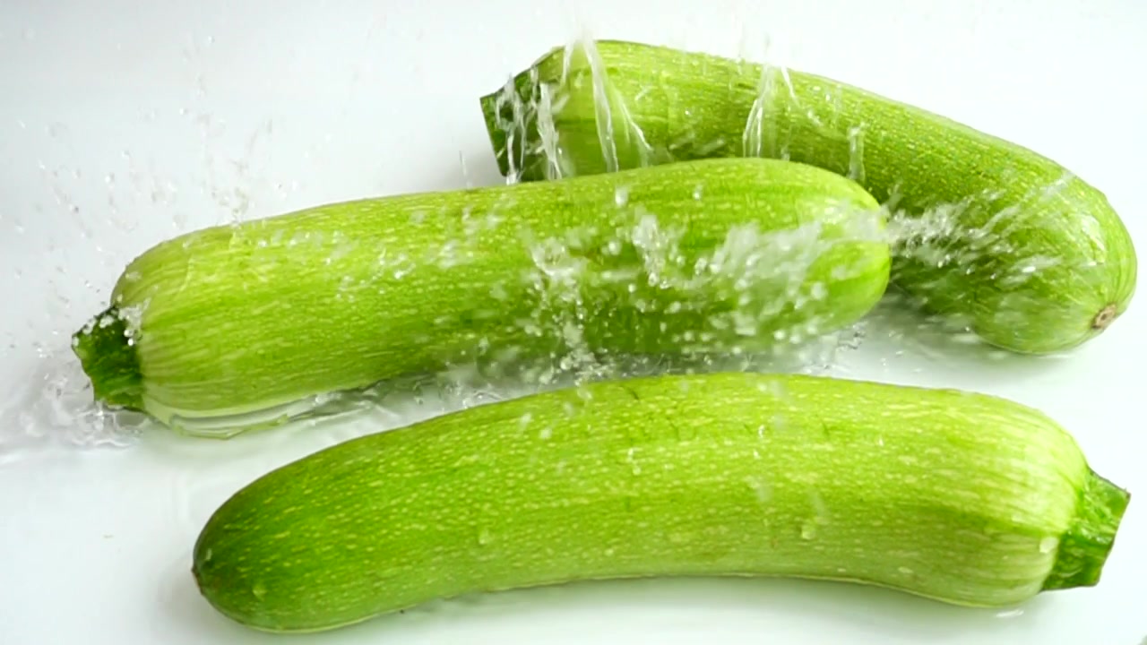 Zucchine e spruzzo d'acqua. Slow motion
