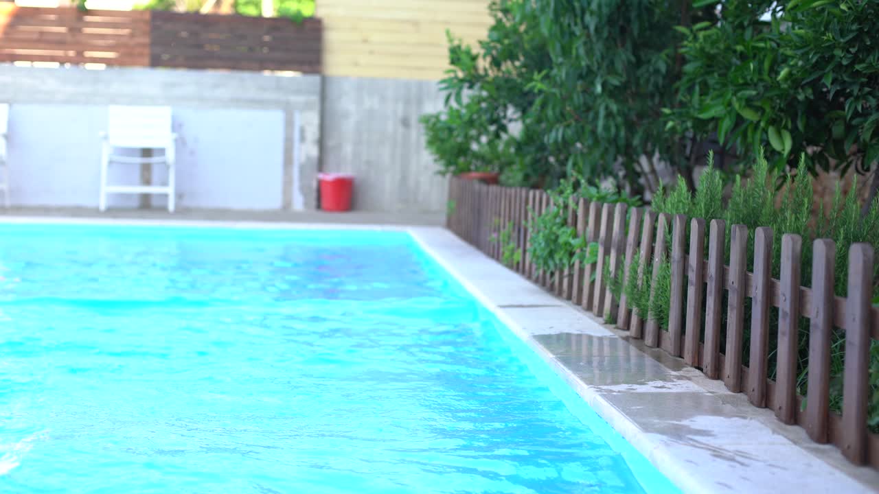 niña bonita nadando en la piscina al aire libre y divertirse con brazaletes inflables
