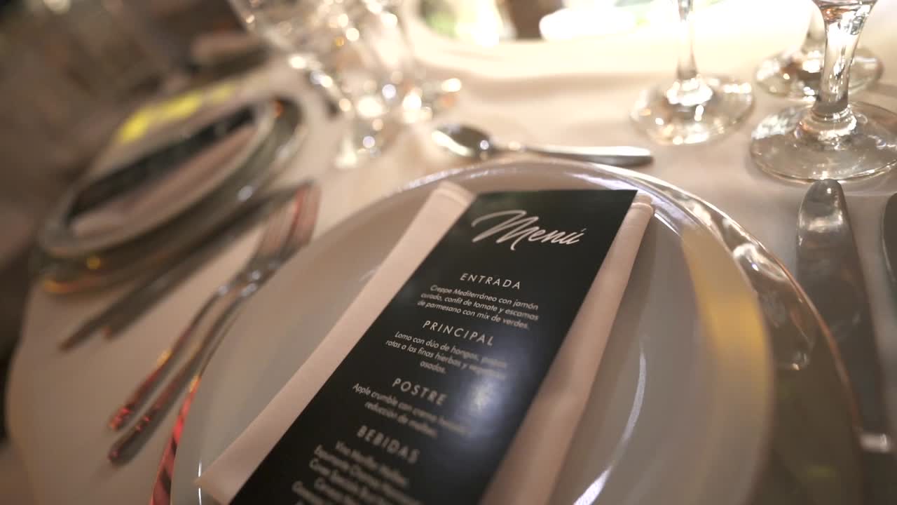 Stylish wedding table with elegant cutlery and menu card lit by soft event lighting