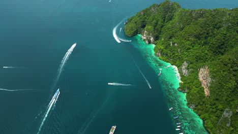 Boats-speed-through-the-deep-blue-water-of-the-Andaman-sea-leaving-white-wake