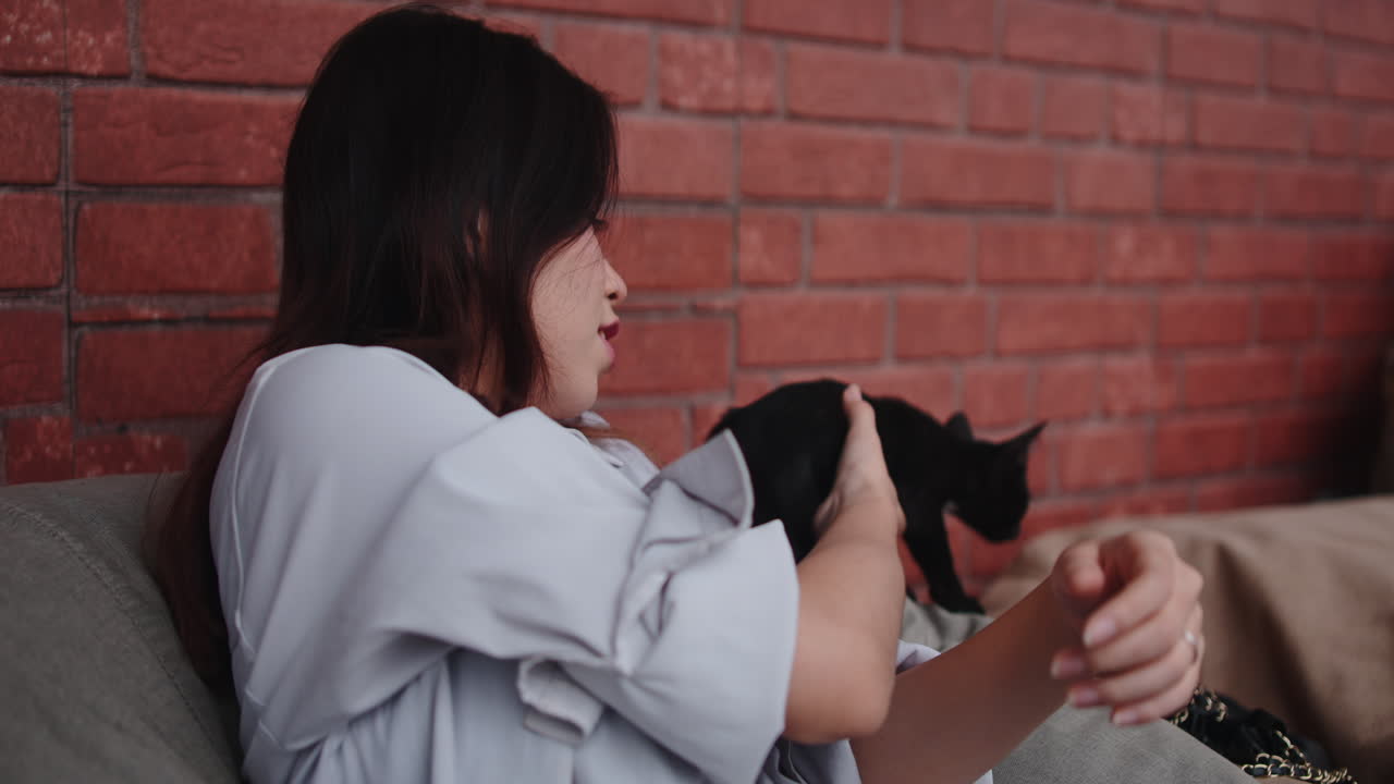 Woman holding a black cat