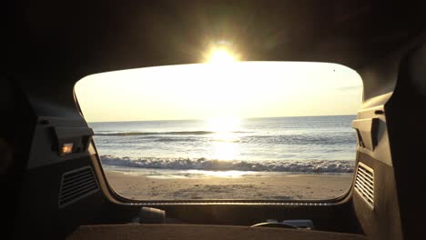 Toma-Deslizante-De-La-Puesta-De-Sol-Y-La-Vista-Al-Mar-Desde-El-Maletero-De-Un-Automóvil