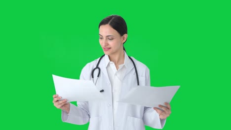 Happy-Indian-female-doctor-checking-medical-reports-Green-screen
