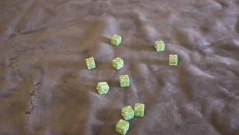 ángulo de punto de vista de un puñado de dados de color verde lima que se lanzan a cámara lenta