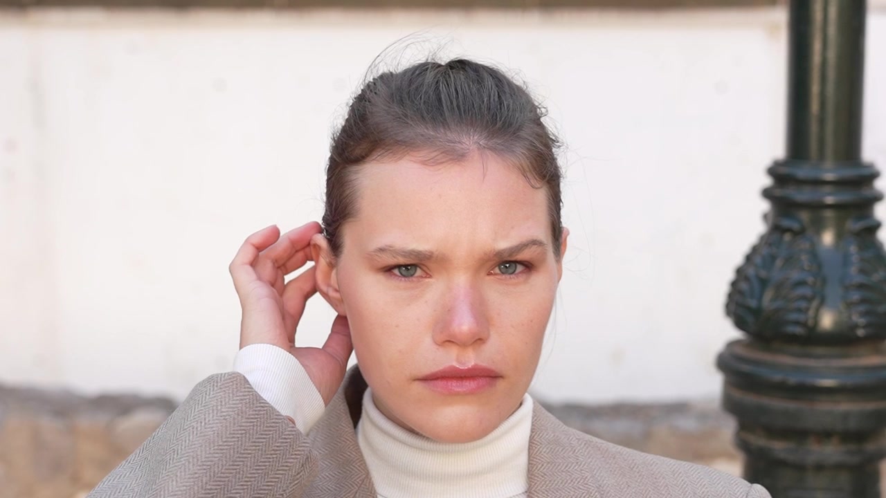 A sophisticated and stylish portrait of a young woman captured in an urban environment