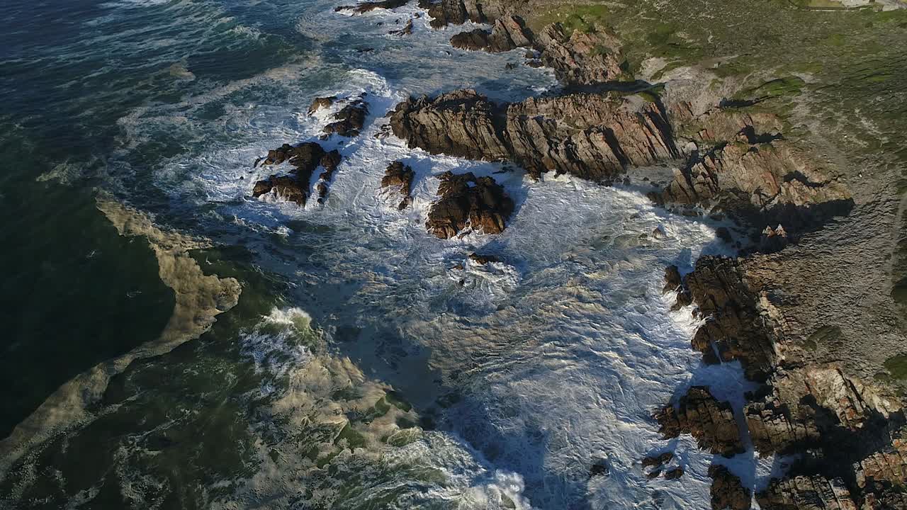 Vue aérienne d'une côte maritime rocheuse tandis que les vagues blanches de l'océan s'écrasent sur le rivage
