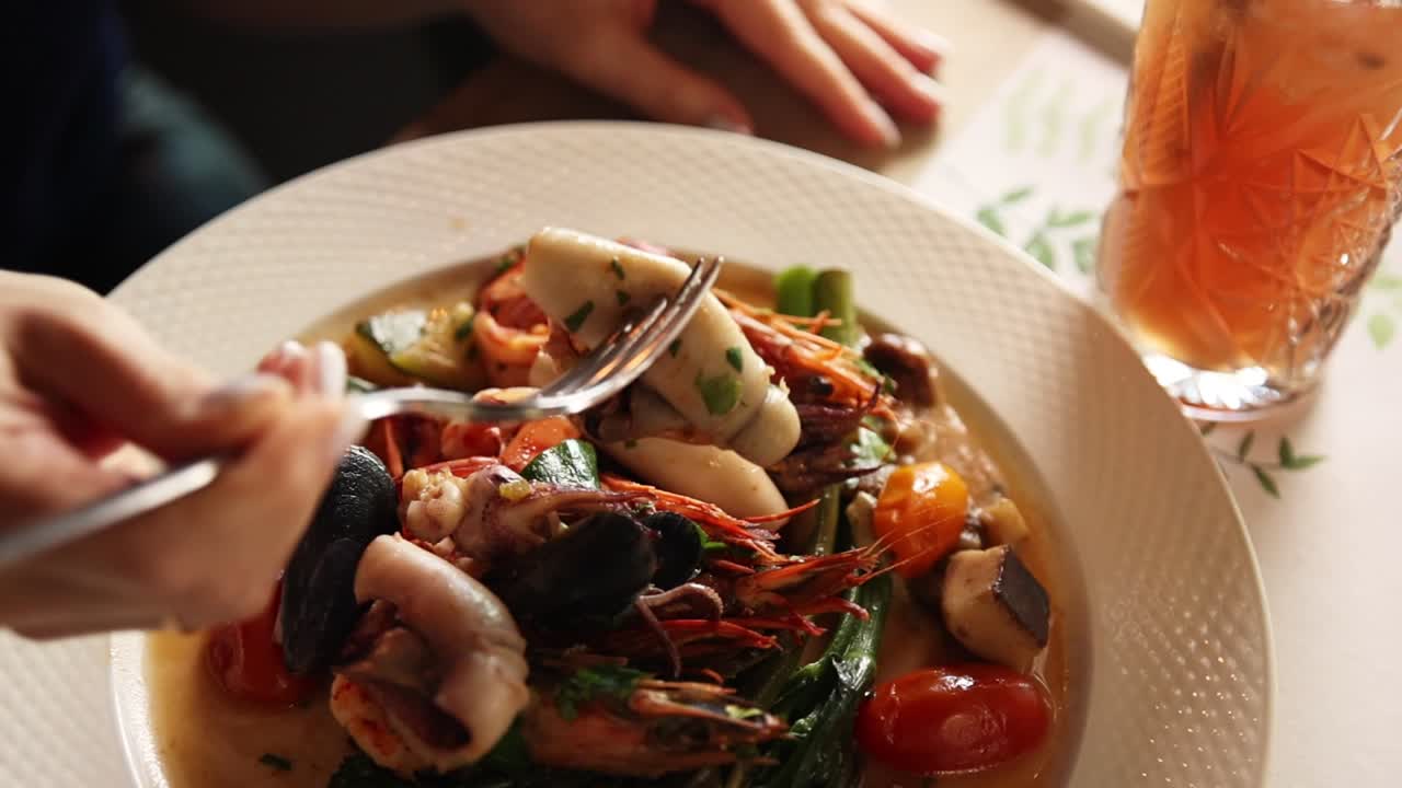 Close-Up of a Person Eating Delicious Seafood Dish with Fork