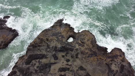 4k 30fps aerial footage of thor's well - epic top down flying shot - aerial view of sun shining against wet oregon coast rock - turquoise blue water, mossy rock, smooth dji drone video