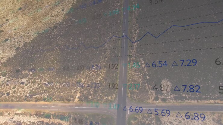 Displaying aerial T?intersection road network cutting arid scrubland with data grid overlays