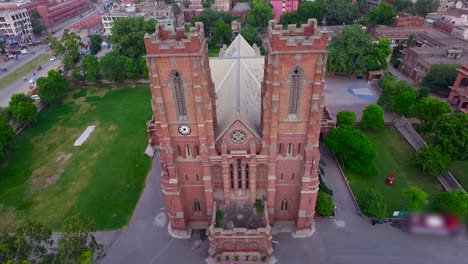vista aérea de una hermosa iglesia antigua, ciudad en el fondo, hermosos árboles y césped alrededor de la iglesia, gente moviéndose fuera de la iglesia