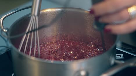 confectioner stirs caramel in saucepan staying at cooker