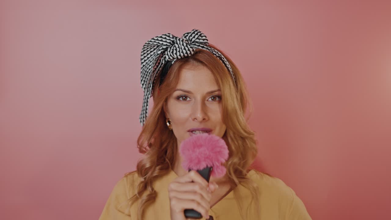 Woman Singing with Microphone and Pink Accessory