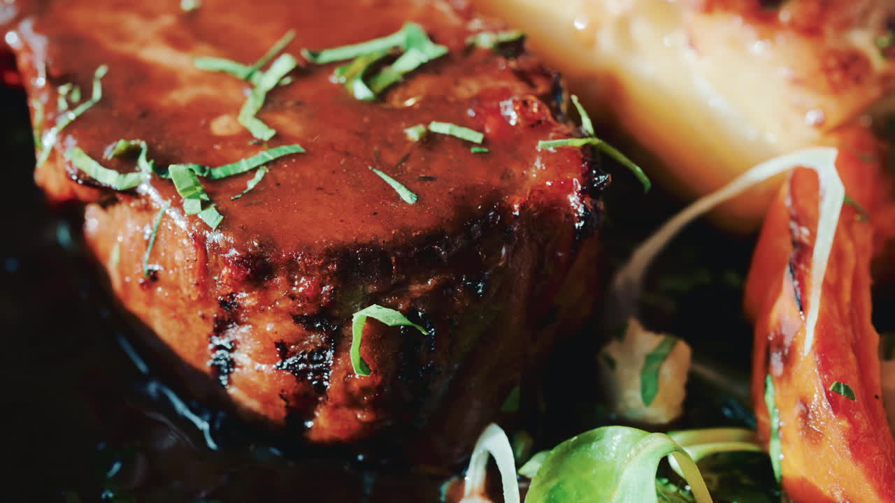 Close up of a gourmet meat dish with grilled vegetables, herbs, and rich sauce
