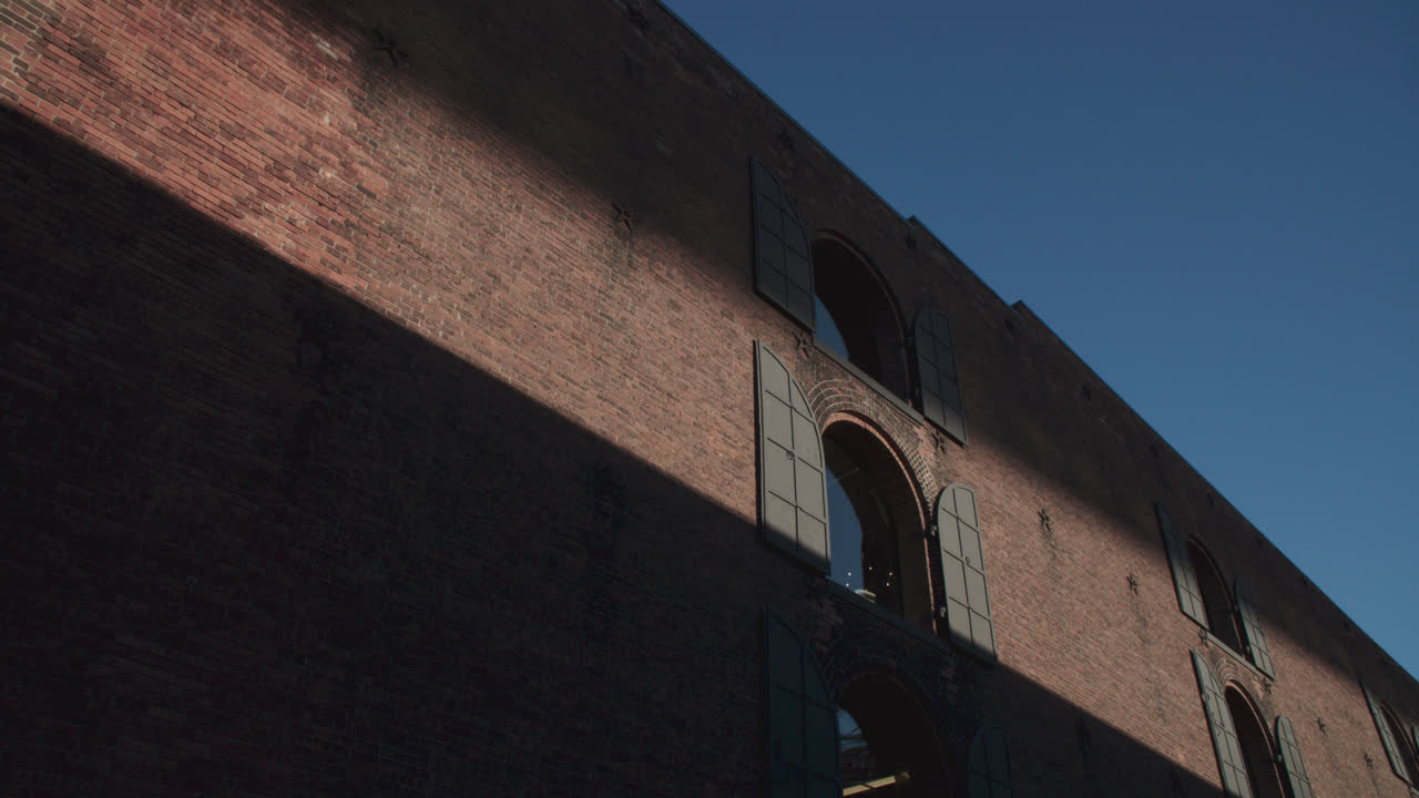 Shadows and a beam of light cast on a brick wall in Brooklyn