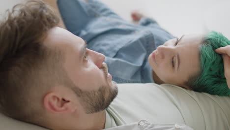 close up view of young couple sitting on sofa, talking and caressing each other