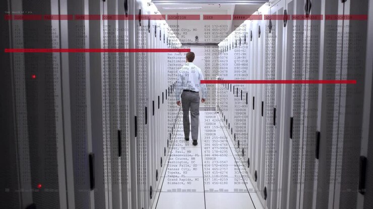 IT technician walking down server corridor, showing server racks, code overlays and red scan bars