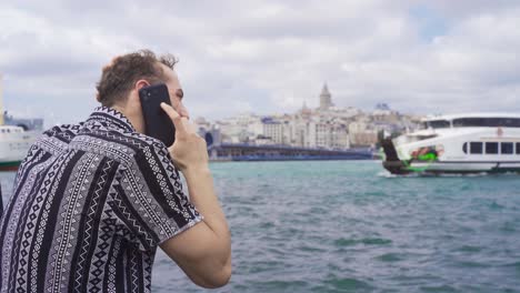 Man-talking-on-the-phone-by-the-sea.