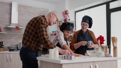 grandparents enjoying spending time with granddaughter cooking gingerbread dessert