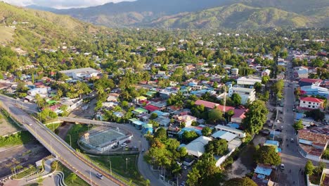 Tägliche-Aktivitäten-Und-Sehenswürdigkeiten-In-Der-Hauptstadt-Dili,-Timor-Leste-In-Südostasien,-Menschen,-Die-Fußball-Spielen,-Verkehr-Auf-Den-Straßen-Und-Blick-Auf-Die-Schützende,-Zerklüftete-Hügellandschaft,-Luftdrohne