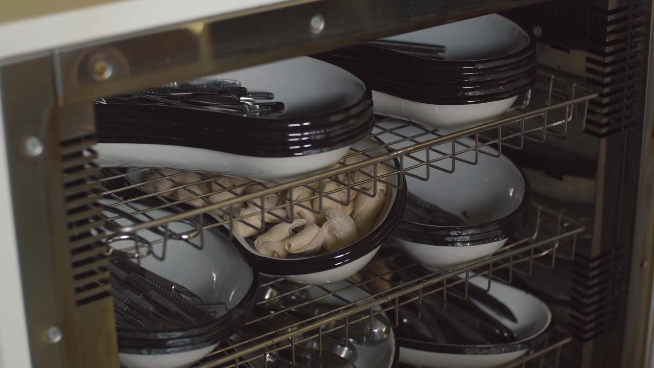 Hand Taking Cutlery From A Dish Warmer