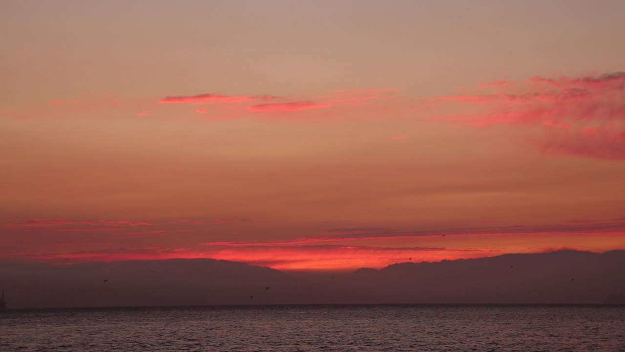 산 프란시스코 만에서 아름다운 여름 밤에 황혼에 놀라운 은 해가 지는 모습, 멀리서 알카트라즈와 골든 게이트 다리가 보인다.