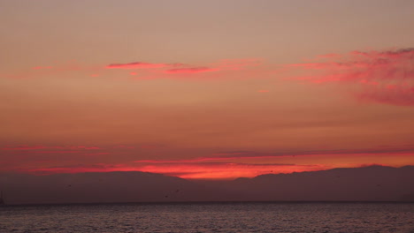 stunning red sunset at dusk on a beautiful summer night in the san francisco bay with alcatraz and the golden gate bridge in the distance