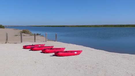 establishing shot, scenic view of beach shoreline in isla holbox, mexico, red pump boat on the sand in the background