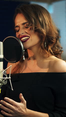 beautiful young singer who recorded a song in a professional recording studio. female vocal vertical video