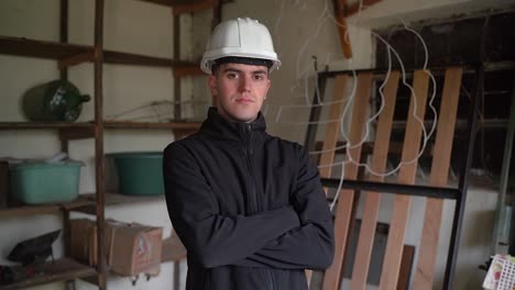 Portrait-Of-Young-Home-Inspector-Wearing-Hard-Hat,-Looking-At-Camera-Inside-The-House