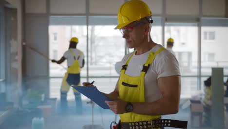 el capataz superior comprobando e inspeccionando con el clipboard en el sitio de construcción