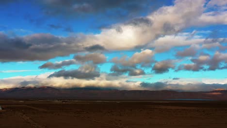 the mojave desert basin, a distant mountain range and lake with clouds and blue sky above at sunset - aerial view