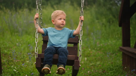 niño juega con columpios hechos a mano pasando tiempo en el suelo