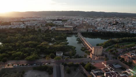 Vista-Aérea-Sobre-El-Río-Guadalquivir,-Una-Antigua-Ciudad-De-Córdoba,-España-Durante-La-Hora-Dorada.