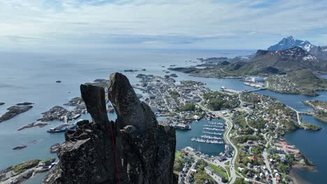 drone glides past the horns of svolvaergeita in lofoten, showing climbing rope and parallax view of svolvaer