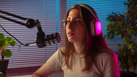 young woman podcasting or streaming into a microphone