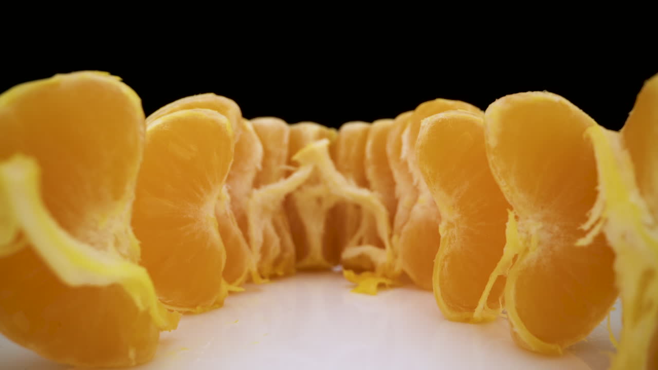 motion from delicious juicy tangerine wedges on white plate