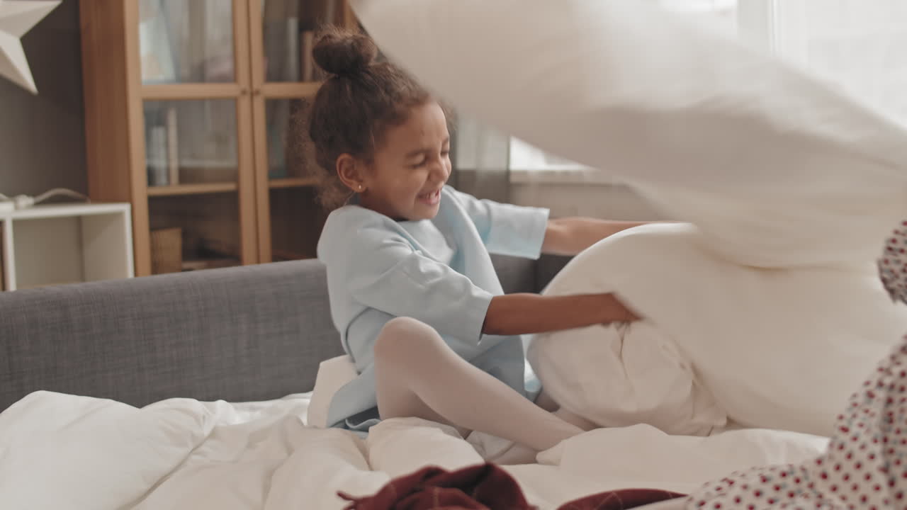 Kids Having Pillow Fight on Bed