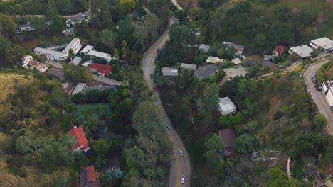 Flying-Over-Cars-on-Winding-Road-Through-Laurel-Canyon,-Whimsical-Rolling-Hills-Neighborhood-in-Los-Angeles-in-Daytime