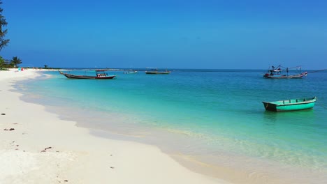 Tropische-Paradiesinseln-Mit-Palmen-Und-Türkisfarbenem,-Welligem-Meerwasser,-Das-Am-Weißen-Sandstrand-Plätschert