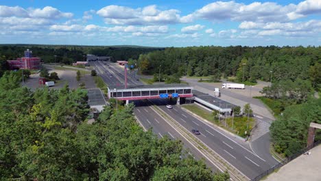 dreilinden checkpoint bravo border crossing. german freeway traffic on sunny day with blue sky. dramatic aerial view flight