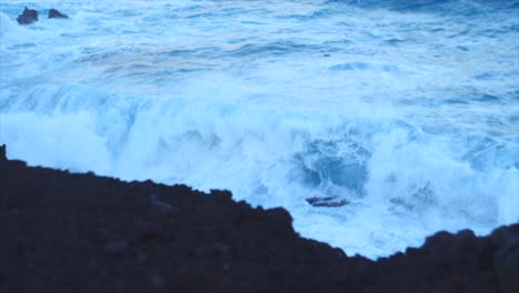 Wellen-Brechen-Bei-Schwachem-Licht-Gegen-Die-Schwarzen-Felsklippen-Auf-Der-Insel-Hawaii