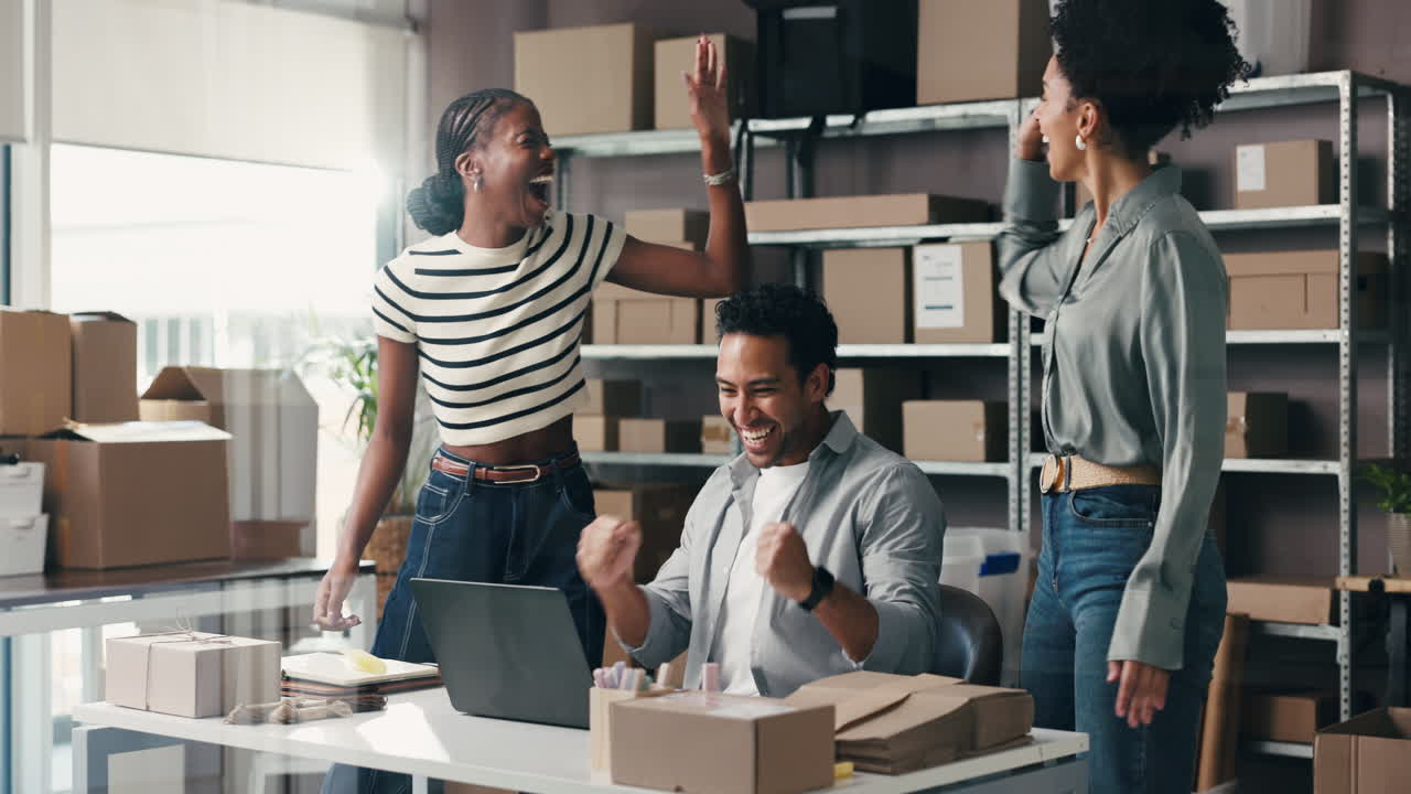 Team diversificato che celebra il successo aziendale in un magazzino e-commerce