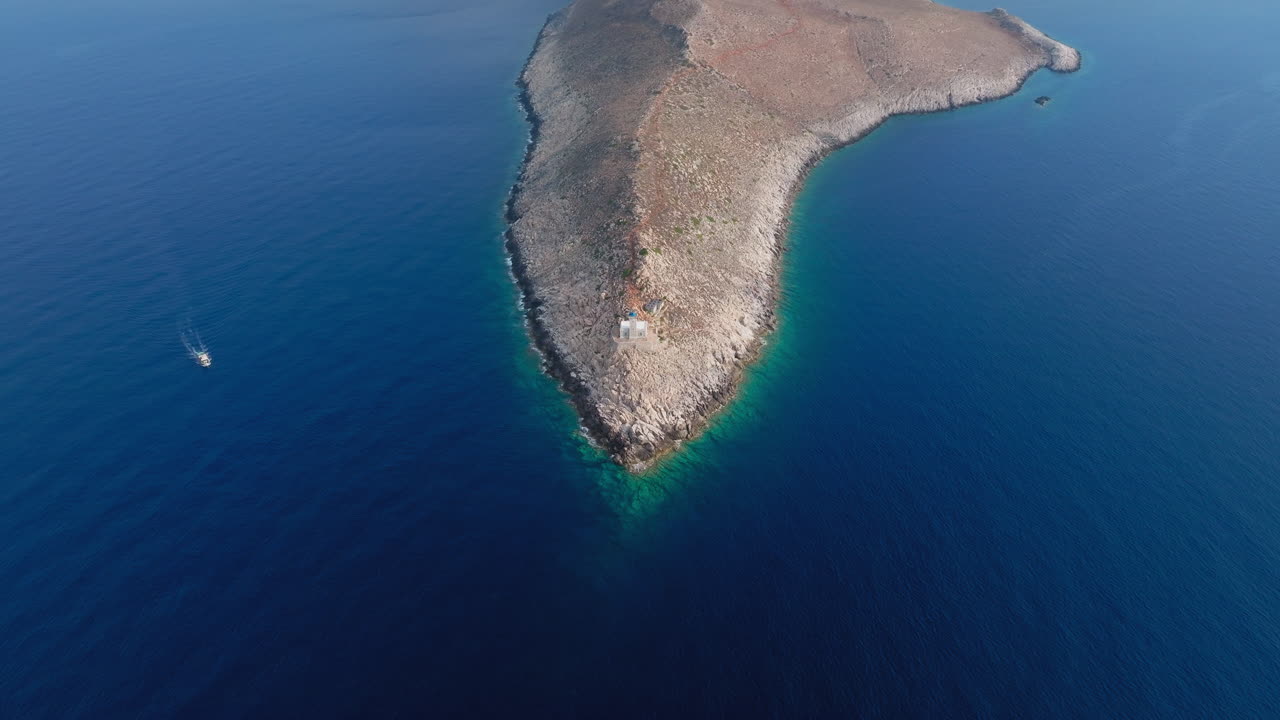 Cape Tainaron from above with rocky land tapering into sea, surrounded by deep blue expanse