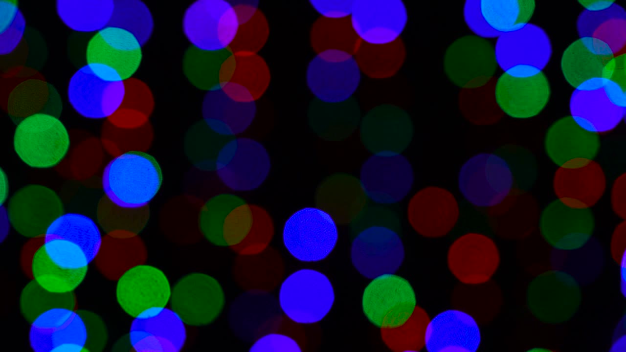 Beautiful blurred background of meteoric multicolored garland, festive seamless loop background