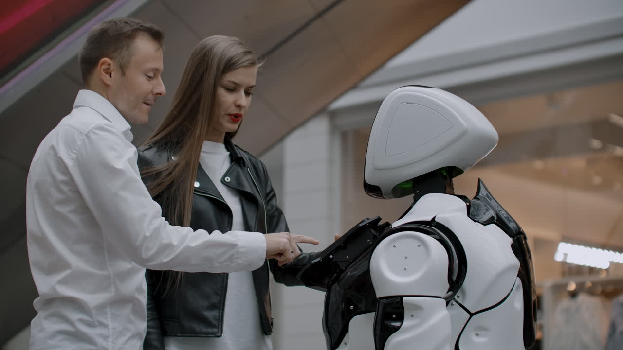 las tecnologías robóticas modernas de interacción con las personas. amistad y comunicación parejas con un robot. asistente al futuro. el robot mira a la cámara a la persona. el robot muestra emociones. levanta las manos baila o es independiente.